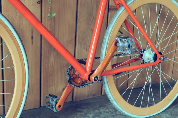 Велосипед с фиксированной передачей, припаркованный с деревянной стеной, крупным планом — стоковое фото