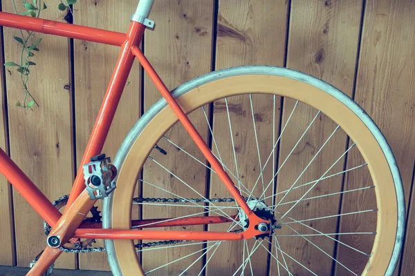 Bicicleta de engrenagem fixa estacionada com parede de madeira, imagem de close-up — Fotografia de Stock