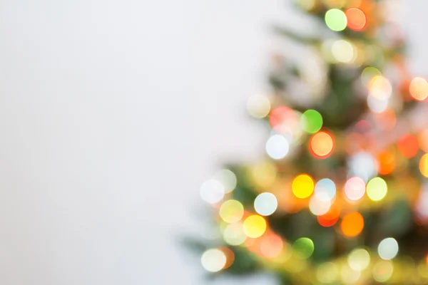 Desenfoque celebración de la luz en el árbol de Navidad con fondo blanco — Foto de Stock