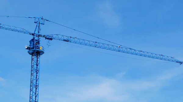 Large construction crane machine with clear blue sky background Stock Picture