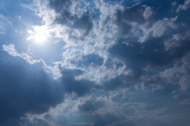 Mavi gökyüzü arka planda güneş Bulutların arasından güneş