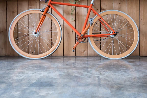 Bicicleta de engrenagem fixa estacionada com parede de madeira, imagem de close-up — Fotografia de Stock