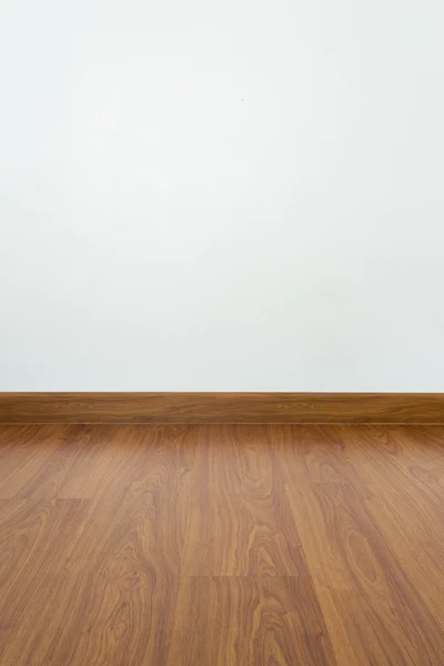 empty room with brown wood laminate floor and white mortar wall