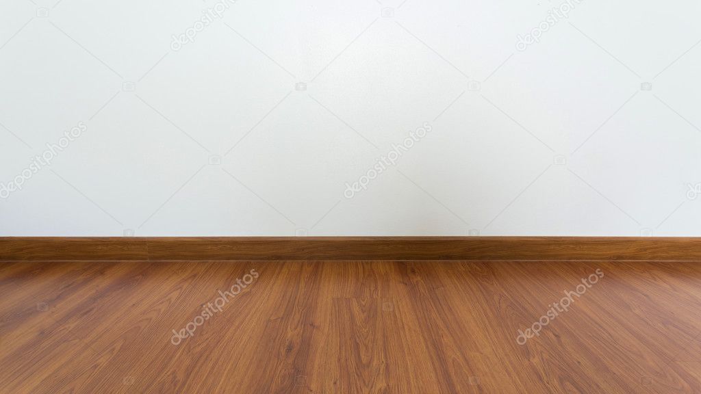 empty room with brown wood laminate floor and white mortar wall 