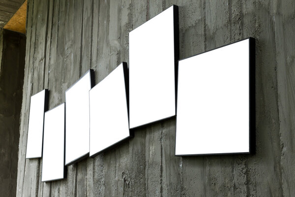 пустая фоторамка висит на цементной стене
