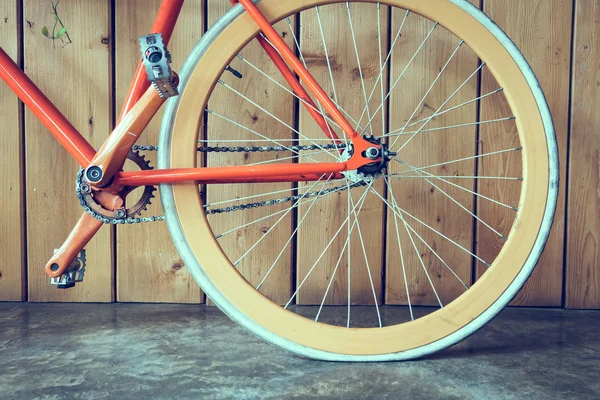 Велосипед с фиксированной передачей, припаркованный с деревянной стеной, крупным планом — стоковое фото