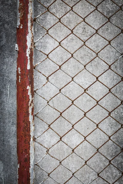 Cerca de arame enferrujado com parede de cimento grunge fundo — Fotografia de Stock