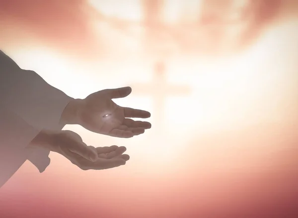 Ascension day concept: Jesus Christ hands showing scars for Thomas over blurred cross sunset background