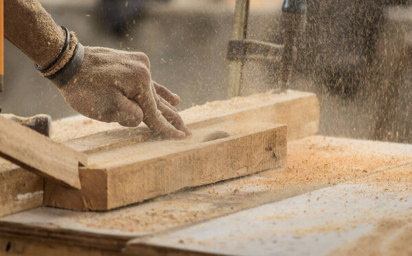 Концепция мебели ручной работы и ремесла: плотник занимается обработкой древесины на лесопилке
