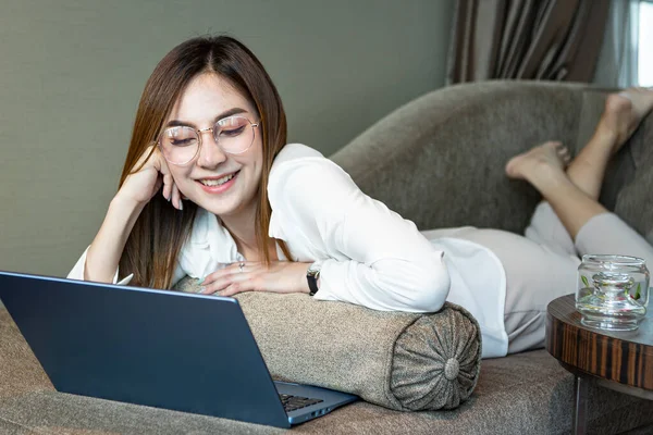 Work from home concept: Beautiful Asian woman using laptop while working the living room