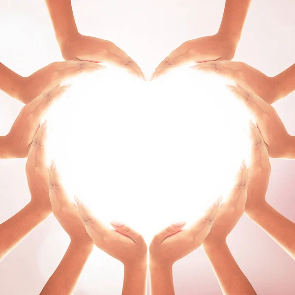 Health care concept: Human hands in shape of heart on blurred natural background