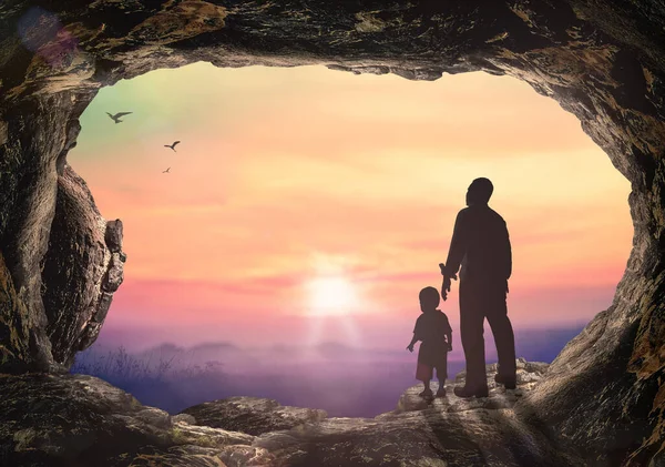 シルエット父親と息子手を取り合って墓石日没の背景 — ストック写真