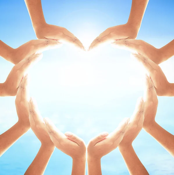 World health day concept: Human hands in shape of heart on blurred sun light and blue sky with ocean background