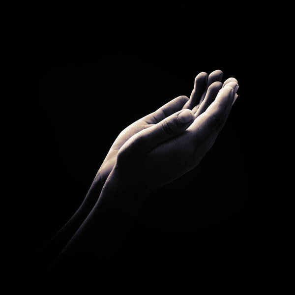 Концепция Рамадана Карим: Черно-белая мусульманская молитва открывает две пустые руки с поднятыми ладонями на фоне темной комнаты