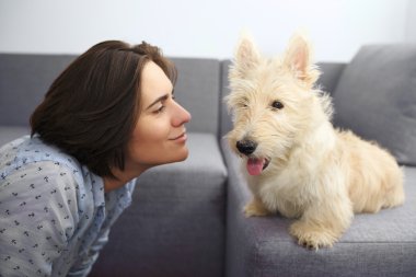 Genç kadın bir köpek vasıl ev ile. 