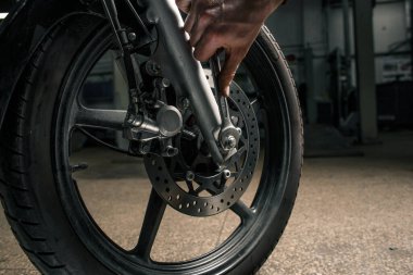 Garajdaki tamirat sırasında motosiklet tekerleğini kapat. İnsanın hobi konsepti