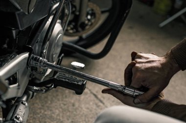 Motosiklet şeyiyle adamın elini kapat. Motosiklet tamir eden genç adam. İnsanın hobi konsepti