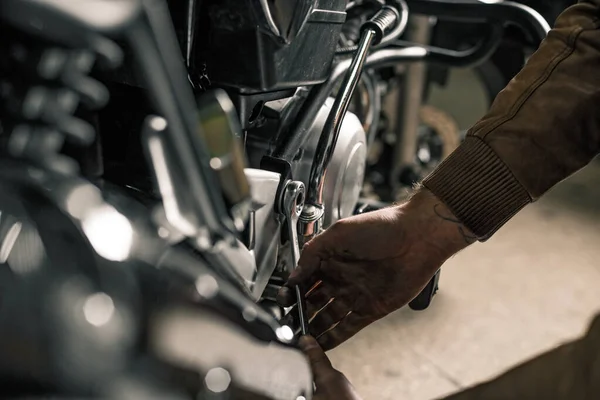 Motosiklet şeyiyle adamın elini kapat. Motosiklet tamir eden genç adam. İnsanın hobi konsepti