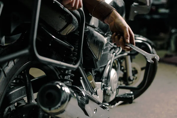 バイクで人の手を閉じてください バイクを修理してる若い男 男の趣味の概念 ロイヤリティフリーのストック画像
