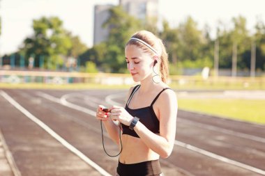 Çalışan bir pistte akıllı saati ve oyuncusu olan kız