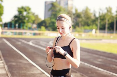 Sportif gülümseyen kız oyuncuyu tutuyor  