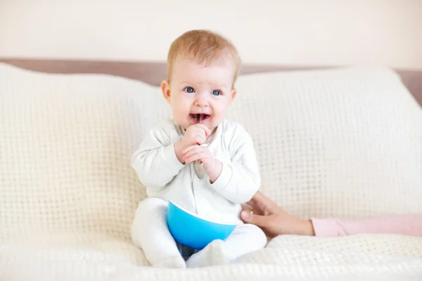 Baby girl with bowl and spoon in her hand — Stock Photo, Image