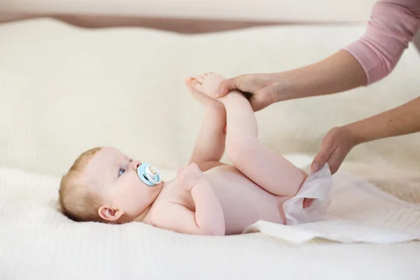 Madre cambiando un pañal a una niña — Foto de Stock