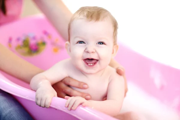 Мати миє дитину у рожевій ванні — стокове фото