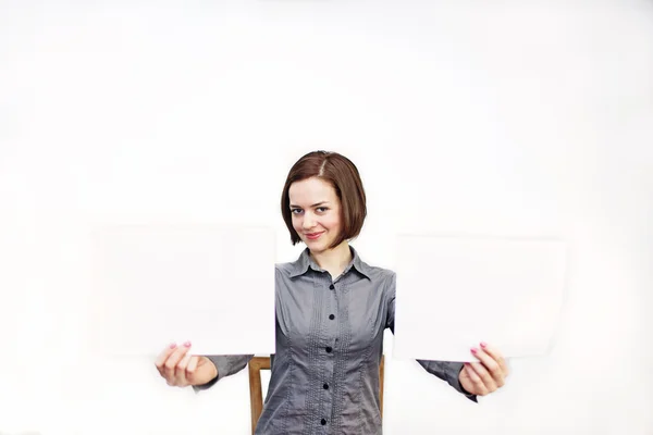 Menina segurando duas folhas brancas de papel . — Fotografia de Stock