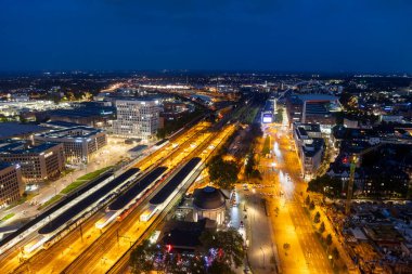 Köln istasyonu Koln Messe Deutz 'un akşam hava manzarası ve Köln Şeytan Üçgeni' nden görünen aydınlatılmış tren rayları.