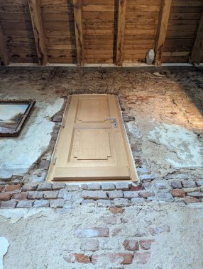 Eski bir tuğla duvarın içindeki kapı garip bir şekilde ikinci katta, yerin üstünde duruyor. Alışılmadık konumu, yaşlı bina karakterine gizem ve cazibe katıyor..