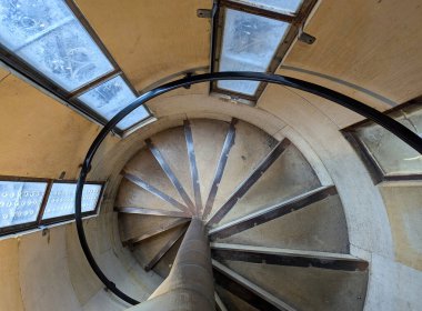 Köln Katedral Kulesi 'nin içinde sarmal bir merdiven, tarihi mimari, karmaşık taş ayrıntılar, doğal ışık ve dingin kutsal atmosfer bulunur..