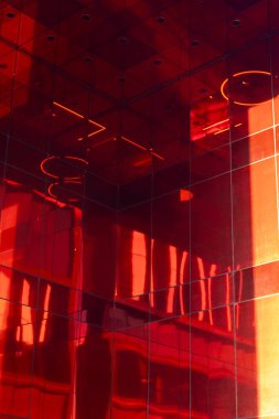 Modern bir iş merkezi, parlak kırmızı cam cepheli ve modern mimarisi iş ufuk çizgisini yansıtıyor..