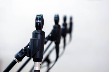 Bir stüdyoda mikrofonlara yakın çekim yapmak, sesi hassasiyetle yakalamak, müzik veya ses kaydetmek için kontrol altında tutulan kablolar ve ekipmanlarla çevrili olmak..