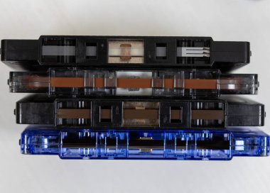 Çeşitli eski ses kasetleri sade bir arka planda, gösterişli retro tasarım, renkli etiketler ve müzik tarihinin nostaljik unsurları üzerine düzenlenmiştir..