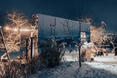 Büyülü bir kış akşamında sıcacık bir kafe sıcacık parlar. Pencerelerden gelen altın ışıklar yağan karı ve sessiz sokağı aydınlatıyor. Soğuk şehirde davetkar ve peri masalı bir atmosfer yaratıyor.