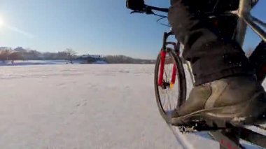 Bisiklet, kışın açık, donmuş bir gölette sürüyor.