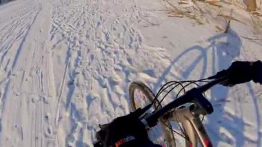 Bisiklet, kışın açık, donmuş bir gölette sürüyor.