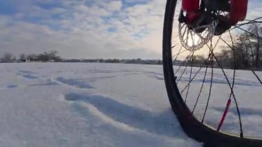 Bisiklet, kışın açık, donmuş bir gölette sürüyor.