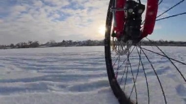 Bisiklet, kışın açık, donmuş bir gölette sürüyor.