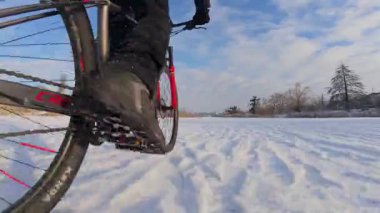Bisiklet, kışın açık, donmuş bir gölette sürüyor.
