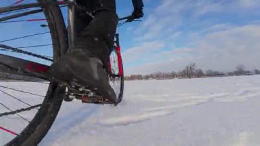 Bisiklet, kışın açık, donmuş bir gölette sürüyor.