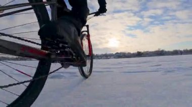 Bisiklet, kışın açık, donmuş bir gölette sürüyor.
