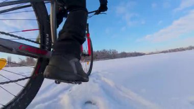 Bisiklet, kışın açık, donmuş bir gölette sürüyor.