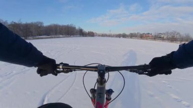 Bisiklet, kışın açık, donmuş bir gölette sürüyor.