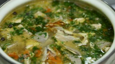 Canlı yeşil otlarla taze hazırlanmış balık çorbası paslanmaz çelik bir tencerede usulca kaynıyor. Net et et suyu, taze balık parçaları ve aromatik buhar sağlıklı ev yapımı yemek için davetkar bir sahne yaratır..