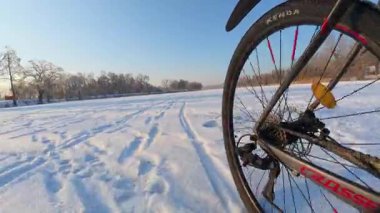 Donmuş gölet yüzeyi ve çok düşük açıyla görülen bisiklet lastiği..