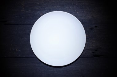 Ahşap arka plan üzerinde üstten görünüm izole boş beyaz tabak