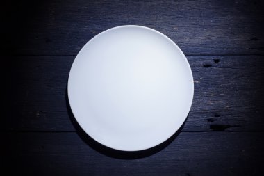 Ahşap arka plan üzerinde üstten görünüm izole boş beyaz tabak