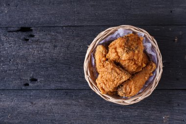 Ahşap masa üzerinde bir sepet içinde çıtır kızarmış tavuk. Üstten Görünüm